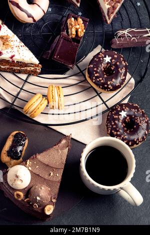 Table with various cookies, donuts, cakes, cheesecakes on dark background.  Delicious dessert table. Top view, flat lay Stock Photo