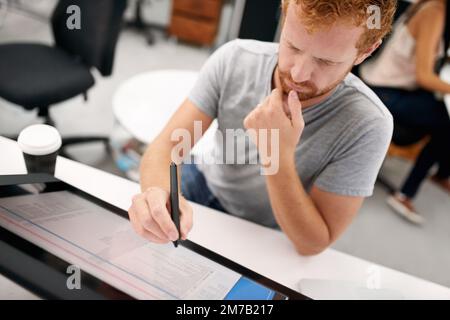 Smart technology makes everything easier. A young man working on a large touchscreen. Stock Photo
