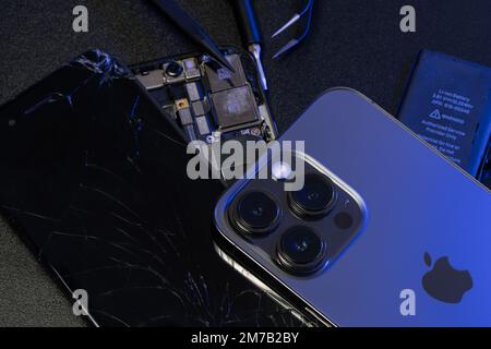 South Tyrol, Italy - Jan. 7. 2023: Apple iPhone 13 Pro on top of old iPhone and repair tools Stock Photo
