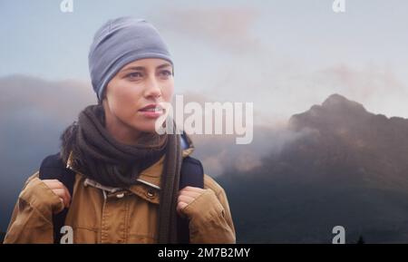 Its all about reaching the top. an attractive young female hiker with the mountain in the background. Stock Photo