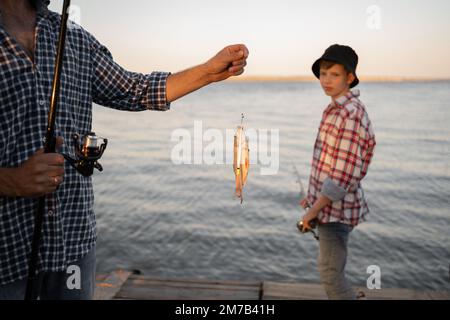 Man caught a fish boy son in the background. Stock Photo