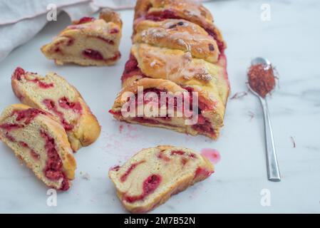 Sweet home made saffron babka brioche with raspberries on a table Stock Photo