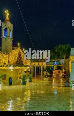 Nazareth, Israel - January 06, 2023: Evening view of the yard of the Greek Orthodox Church of the Annunciation (Saint Gabriel), with Christmas lights, Stock Photo