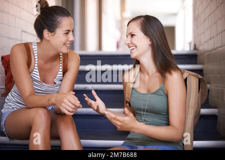 Chilling with my bestie between class. Two female college students talking in the hallway. Stock Photo