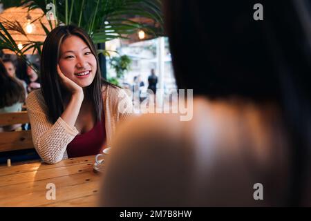 woman enjoys date with a friend in a coffee shop Stock Photo