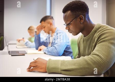Black man, students and studying for education, knowledge and focus for exams, campus and intelligent. African American male, student and young people Stock Photo