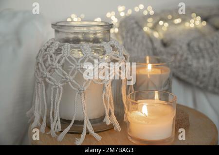 Cozy home composition with burning candles on a blurred background. Stock Photo