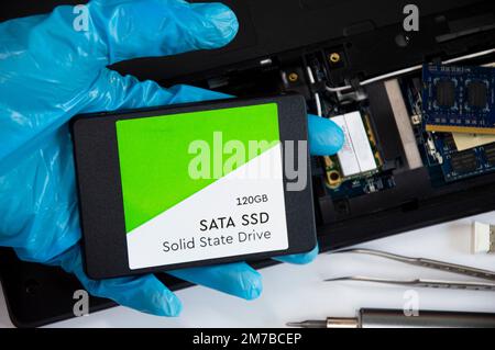 Technician installing ssd drive in old computer, upgrading computer Stock Photo