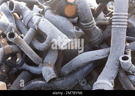 Old rubber hoses that pile together many lines. The tubes are piled up in a warehouse of an enterprise that disassembles old cars for spare parts for Stock Photo