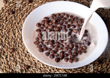 photo chocolate balls in a white round plate pour milk on top Stock Photo