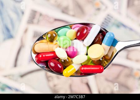 colourful pills on a spoon against Swedish krona, cutout Stock Photo