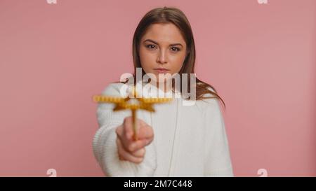 Magician witch woman gesturing with magic wand fairy stick, making wish come true, casting magician spell, advertising holidays sale discount. Young adult girl isolated on pink studio background Stock Photo