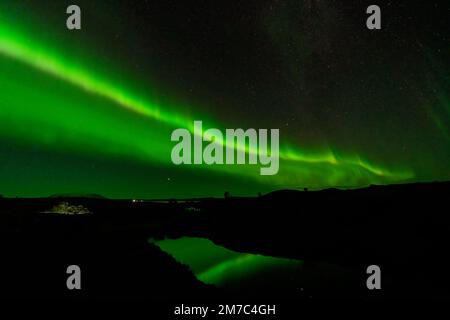 Aurora Borealis green beams with lake reflection Stock Photo