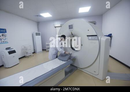 HANGZHOU, CHINA - JANUARY 9, 2023 - A radiologist at a community health Service center disinfects the place where people lie on their backs with alcoh Stock Photo