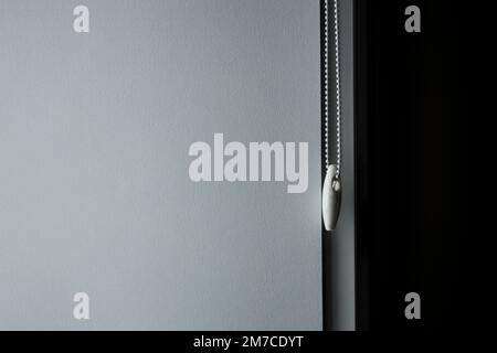 Roller Blinds or curtains at the glass window. Details of grey fabric roller blinds Stock Photo