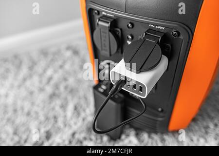 Inverter generator charges the power bank battery. Stock Photo