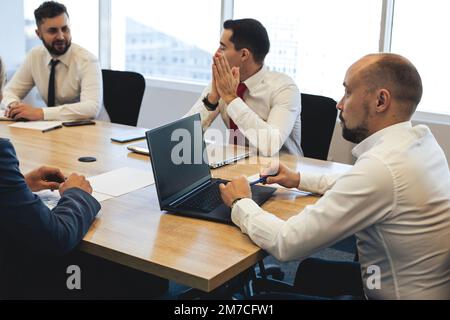 Silhouettes of people sitting at the table. Team of young business people working and communicating together in a modern office. Corporate team and Stock Photo
