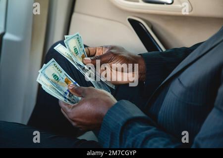 Counting paper money. Close-up of a man's hands counting dollar bills. The concept of earnings and business profitability. Benefit, profit and salary Stock Photo