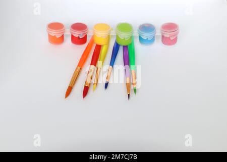 colorful paint brushes laying on a white isolated background depicting kids art Stock Photo