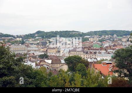 LVIV, UKRAINE - SEPTEMBER 11, 2022 Panorama view of the historical old city in Lviv, Ukraine. Many old buildings with metal roofs and cathedral domes in beginning of autumn day Stock Photo