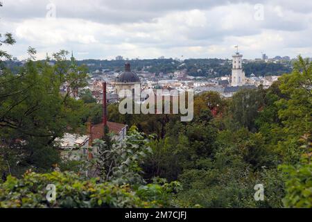 LVIV, UKRAINE - SEPTEMBER 11, 2022 Panorama view of the historical old city in Lviv, Ukraine. Many old buildings with metal roofs and cathedral domes in beginning of autumn day Stock Photo