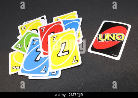 A spread of UNO cards isolated on a black background displaying red, yellow, green and blue Stock Photo