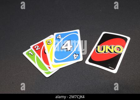 A spread of UNO cards isolated on a black background displaying red, yellow, green and blue Stock Photo