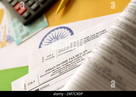 KYIV, UKRAINE - MAY 4, 2022 Indian income tax return blank form with pen and indian rupees bills on indian country flag close up. Annual tax report concept Stock Photo