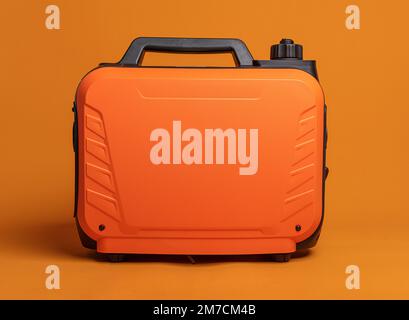 Inverter gasoline generator on an orange background. Stock Photo