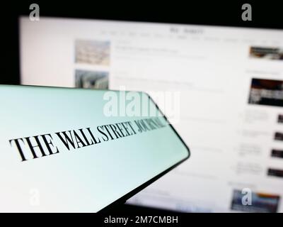 Smartphone with logo of American newspaper The Wall Street Journal on screen in front of website. Focus on center-left of phone display. Stock Photo