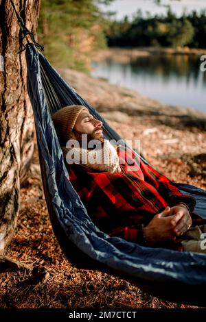 Man relaxing while lying down in hammock Stock Photo