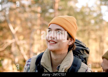 Young smiling man wearing knit hat looking away during hiking Stock Photo