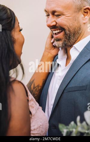 Happy newlywed multiracial couple looking at each other Stock Photo
