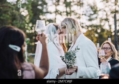 Newlywed couple dancing amidst  family and friends at ceremony Stock Photo