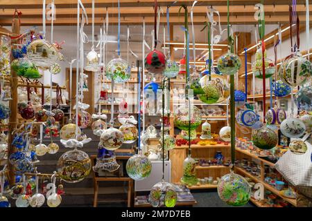 12.10.2022 - Hallstatt, Austria - colorful Christmas tree ornaments hanging in the window of a souvenir store . Stock Photo