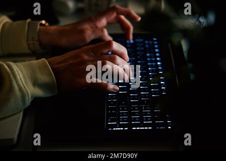 Close up shot of anonymous woman typing on laptop keyboard at night. Online communication and working after hours concept Stock Photo