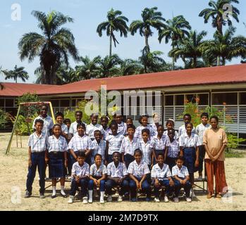 Surinam, Paramaribo. pupils and teacher have a class photo taken in front of their primary school. Stock Photo