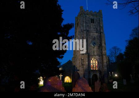 A traditional church and graveyard shown here in the twilight and showing the traditional church tower in the centre of the village in the UK. Stock Photo