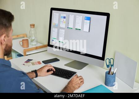 Close up of man working with PC computer at workplace while developing mobile app, copy space Stock Photo