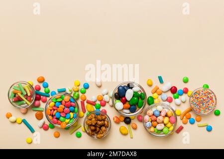 different colored round candy in bowl and jars. Top view of large variety sweets and candies with copy space. Stock Photo