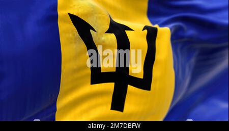 Barbados national flag waving.Blue and yellow flag with a black Triton in the center. Rippled Fabric. Textured background. Selective focus. Realistic Stock Photo