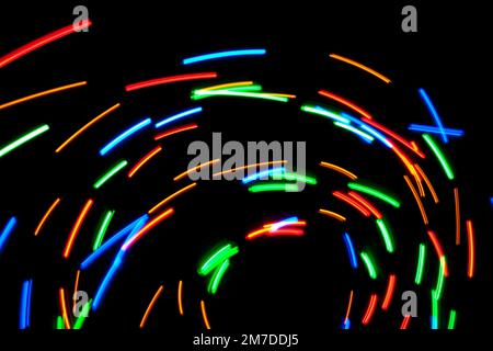 Abstract swirls and patterns of light caused by a spining multicoloured light. Stock Photo