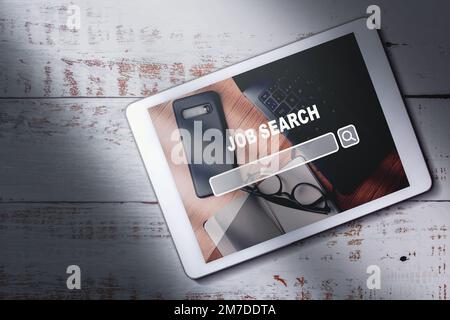 Top view of digital tablet with search job title on screen. Find your career. Using online website to find a job. Stock Photo