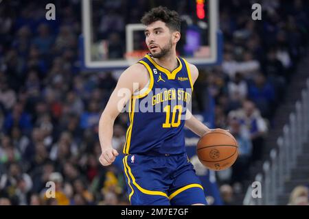 Golden State Warriors guard Ty Jerome (10) tries to swat the ball away from  Toronto Raptors forward Chris Boucher (25) during first half NBA basketball  action in Toronto, Sunday, Dec. 18, 2022.