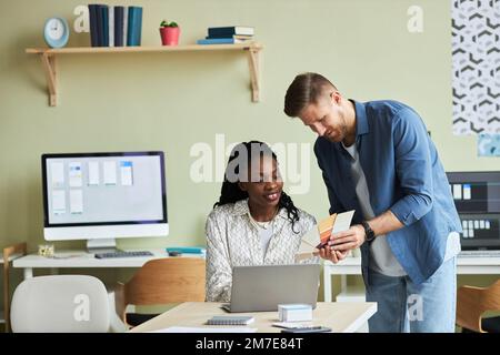 Portrait of two designers looking at color swatches while working on creative project in office, copy space Stock Photo