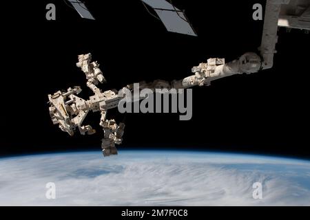 ISS - 01 January 2023 - Dextre, the International Space Station's fine-tuned robotic hand, is attached to the Canadarm2 robotic arm as the orbiting la Stock Photo