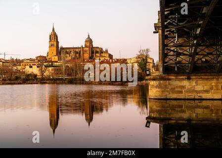 Scenic view of Salamanca with the Cathedral and iron bridge reflected in the Tormes River at sunset. Castilla Leon, Spain Stock Photo