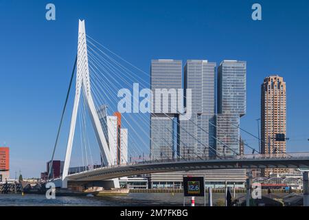 Holland, Rotterdam, View of the Erasmusbrug or Erasmus Bridge over the Nieuwe Maas River with the 3 sectioned De Rotterdam Building in the background. Stock Photo