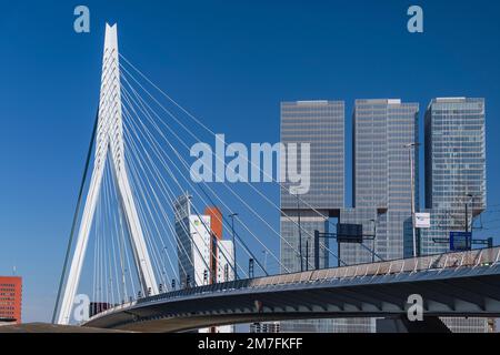 Holland, Rotterdam, View of the Erasmusbrug or Erasmus Bridge over the Nieuwe Maas River with the 3 sectioned De Rotterdam Building in the background. Stock Photo