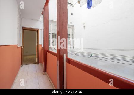 Corridor of a corrala of an urban residential house, stoneware floors and ropes for hanging clothes Stock Photo